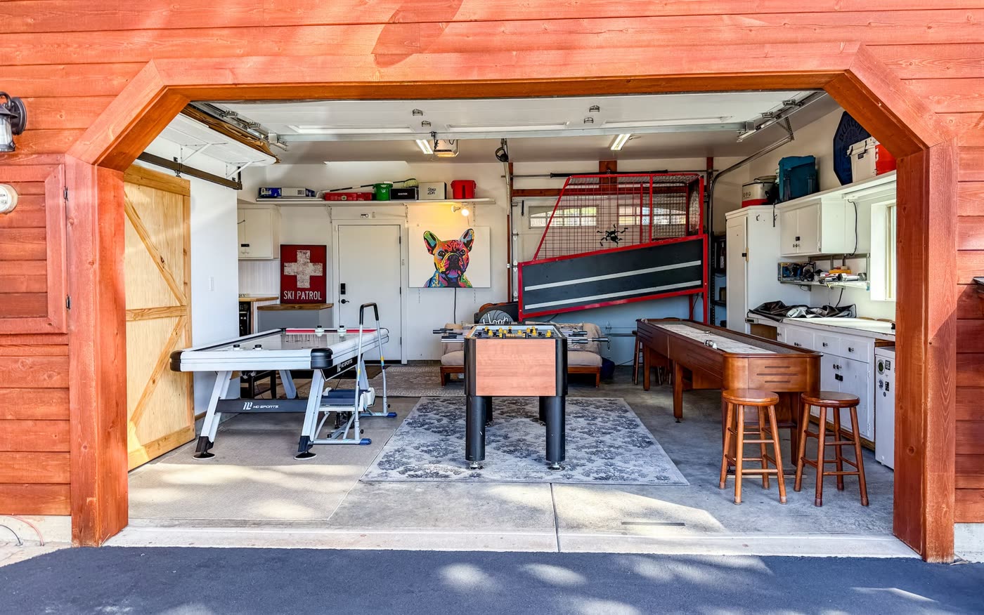 The game garage with the door up: air hockey, foosball, shuffleboard and Hoop Fever