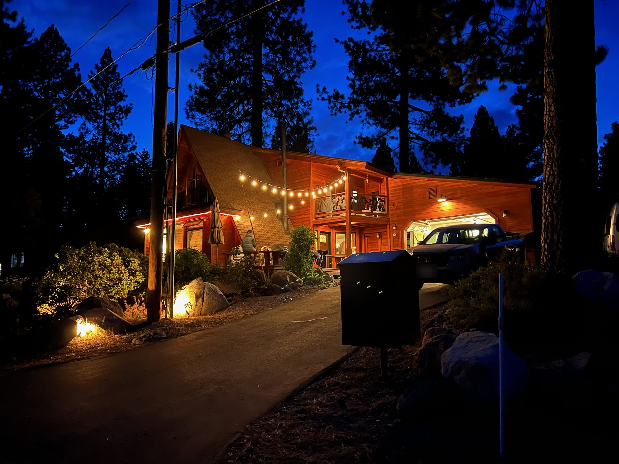 The cabin at night with string lights glowing over the deck