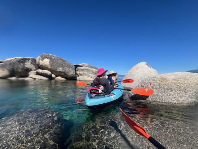 Kayaking through clear water between granite boulders