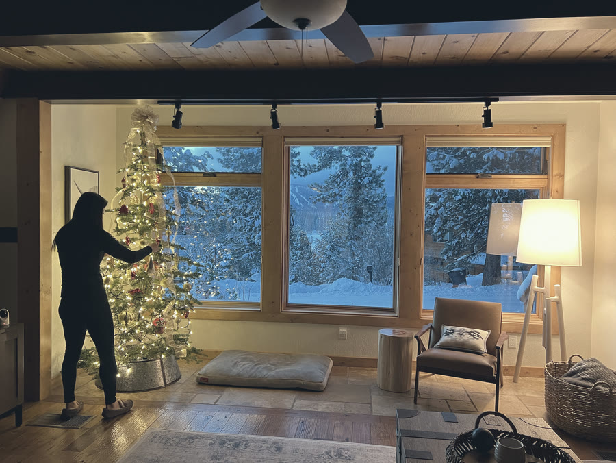 Decorating the tree by the snowy windows